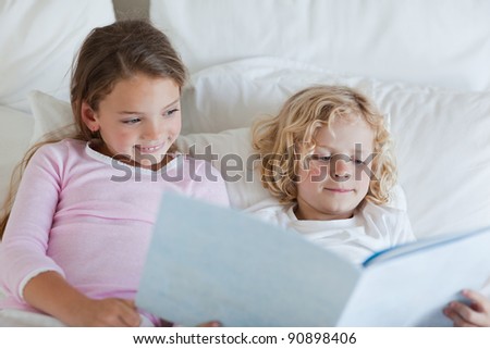 Brother and sister reading bed time story together
