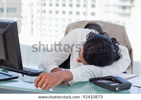 Businessman sleeping on his desk in his office