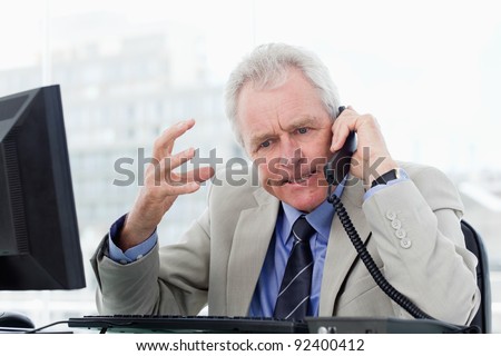 Angry senior manager on the phone in his office