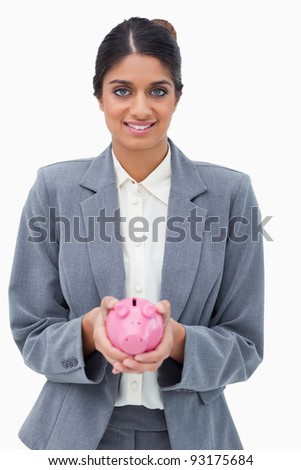 Smiling bank employee holding piggy bank against a white background