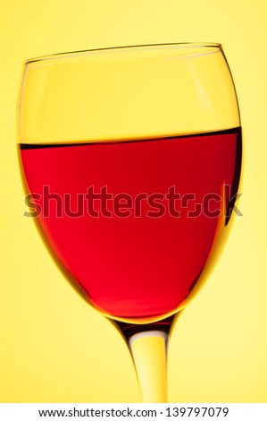 Glass of red wine on yellow background