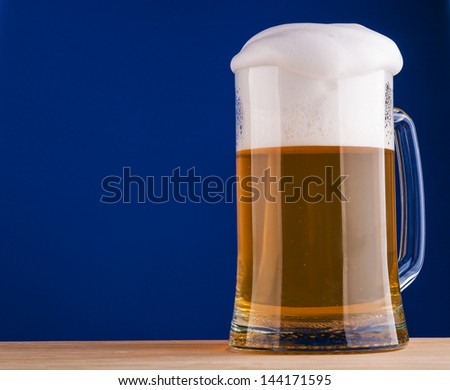 Mug of beer on blue background