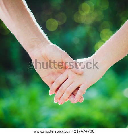 Two hands together on green background