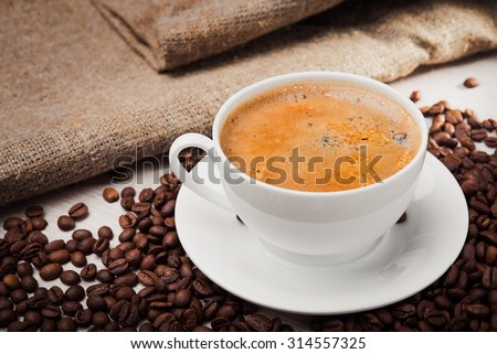Cup with coffee and milk on wooden table