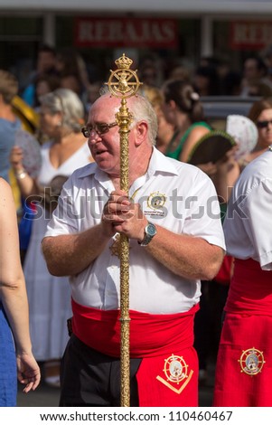 MALAGA, SPAIN - JULY 16: Unidentified local worshipper carry a brotherhood staff during the \'Virgen del Carmen\' procession on July 16, 2012 in Malaga, Spain.