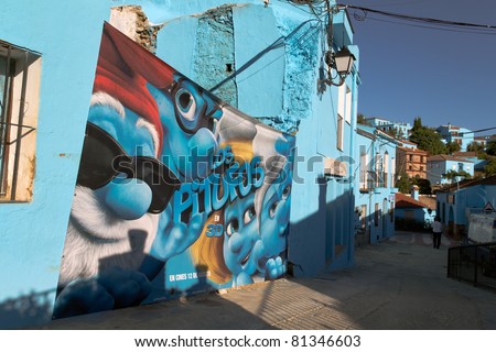 JUZCAR, SPAIN - JUNE 16: Smurfs movie poster on a wall of the village on June 16, 2011 in Malaga, Spain. The village was painted blue for The Smurfs movie launch