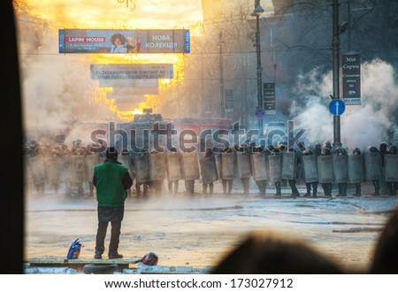KIEV, UKRAINE - JANUARY 24: A row of the riot police and priest at Hrushevskogo street on January 24, 2014 in Kiev, Ukraine. The anti-governmental protests turned into violent clashes during last week