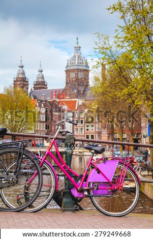AMSTERDAM - APRIL 16: Bicycles parked at the bridge on April 16, 2015 in Amsterdam, Netherlands. It\'s the capital city and most populous city of the Kingdom of the Netherlands.