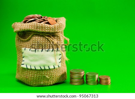 Sack and row of coins over green background