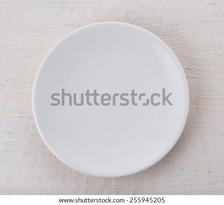 Empty white ceramic plate on wooden table