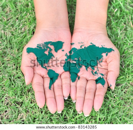 Map of the world in your hands with green grassy background