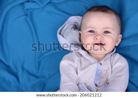 Blue Eyed Baby Boy on a Blue Blanket Smiling