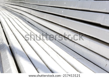 Closeup on long wooden bench creates background of converging lines