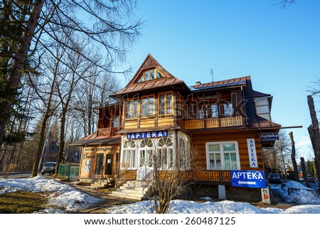 ZAKOPANE, POLAND - MARCH 09, 2015: Traditional Wooden Villa dating from the early of the 20th century, with historic features of architectural heritage. Today, the house pharmacy and a barber shop