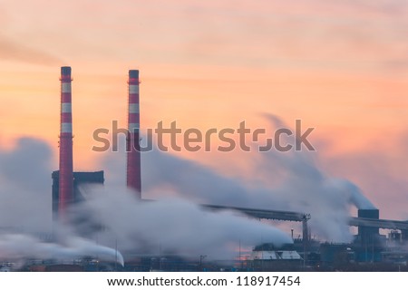 Chemical factory in the morning, with pipes and polluting smoke, long exposure