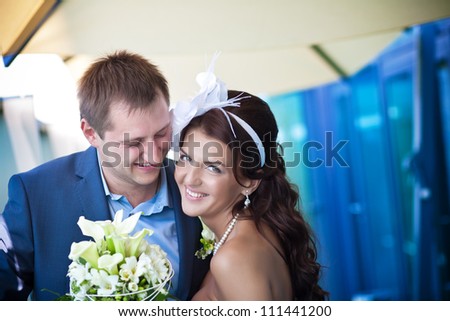 bride and groom is laughing near the glass building