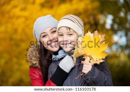Mom and son on a autumn park background