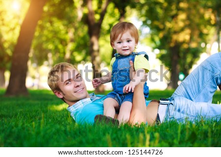 happy daddy with a baby in a beautiful summer park