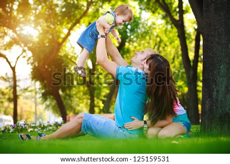 baby with parents in a green summer park