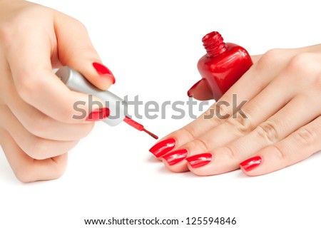 manicure. applying red nail polish