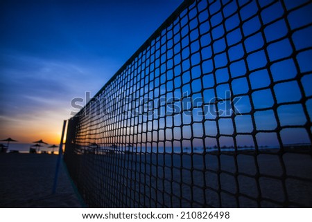 Sillhouette of a volleyball net and sunrise on the beach. summer