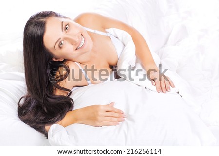 A woman lying in the bed  and smiling
