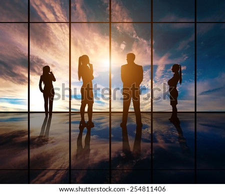 Silhouettes of businesspeople standing against panoramic  window