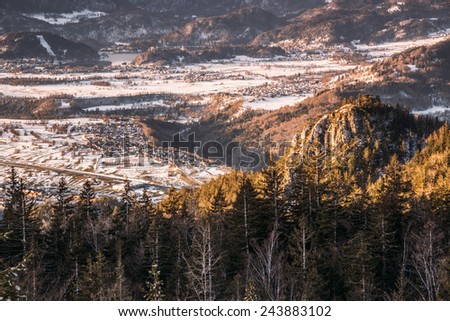 Snowy Forest at Sunrise after Snow. Snowy mountains on an early winter morning. Photograph was taken in Slovenia on the border with Austria.  Panorama with forest, mountains, clouds and clear sky.