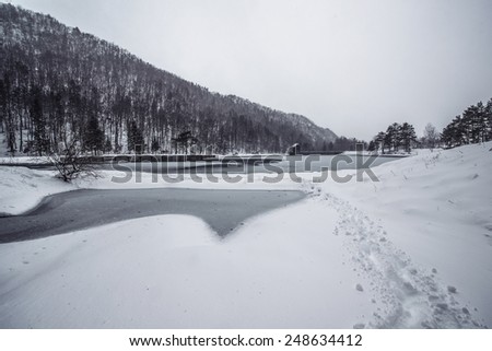 Beautiful winter scenery by the lake and the River. Heavy snow and blizzard is giving the scenery a unique appearance and look.