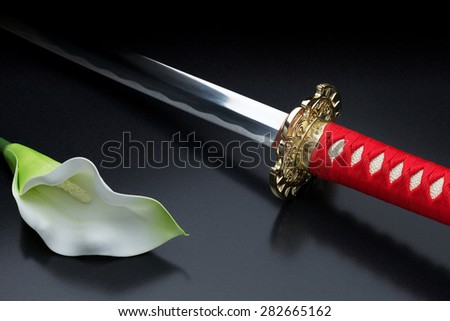 Japanese sword and beautiful flower against a dark background