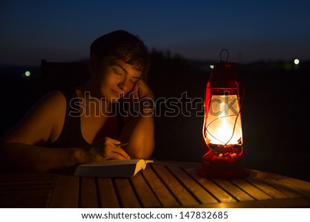 Woman reads the book at oil lamp and  asleep while reading