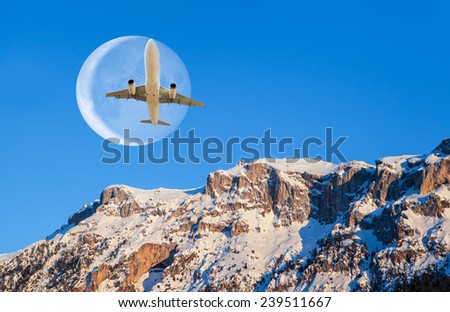 Airplane over the mountains against moon 