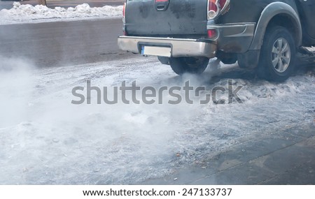 Close-up of gray car exhaust pipe with smoke