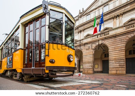 MILAN, ITALY - MARCH 24, 2015: La Scala theater and orange vintage tram in a street of Milan city center