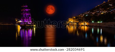 lunar eclipse against to the dockyard of Alanya, Turkey  