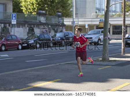 GENEVA - JULY 20: Unidentified young athlete competes in the running section of the 2013 ITU Kidsathlon race, July 20, 2013 in Geneva, Switzerland.