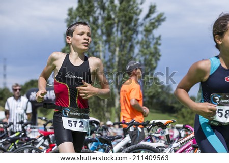 MACHILLY, FRANCE JULY 6, 2014: Unidentified young athletes participate in the running race of the Lake Machilly Triathlon which is part of the TriSaleve of Annemasse organization.