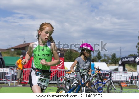MACHILLY, FRANCE  JULY 6, 2014: Unidentified young athletes participate in the running race of the Lake Machilly Triathlon which is part of the TriSaleve of Annemasse organization.