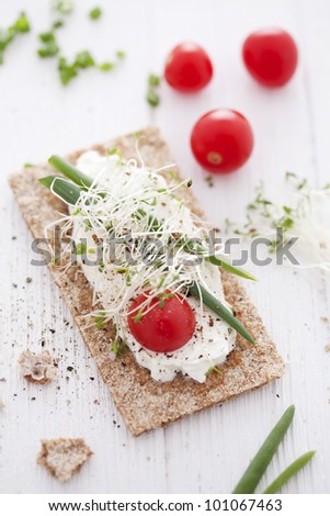 crisp bread sandwich with cream cheese, broccoli sprouts, tomato and chive