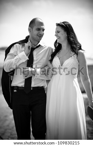 Black and white portrait of newly married couple walking together and smiling
