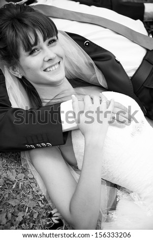 Black and white portrait of bride lying on grooms chest