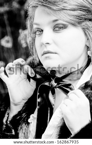 Closeup black and white portrait of chubby woman tying black bow