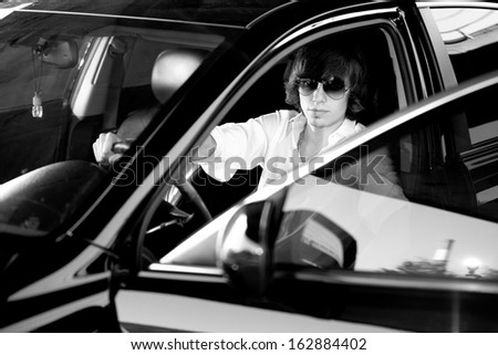 Black and white portrait of elegant man on drivers seat