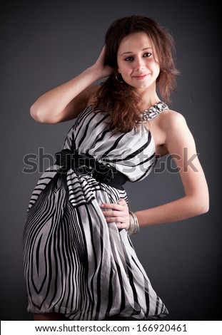 Closeup portrait of sexy brunette with dress and hair lifted by wind at studio