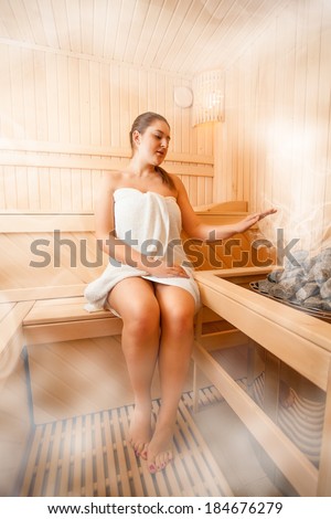 Photo of woman sitting in steamed sauna next to oven