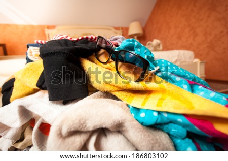 Closeup photo of sunglasses on pile of clothes in suitcase