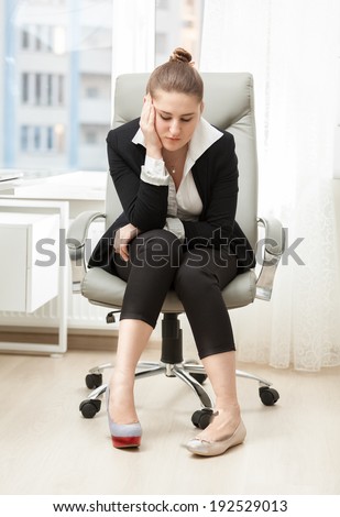 Young businesswoman choosing between comfortable and beautiful shoes