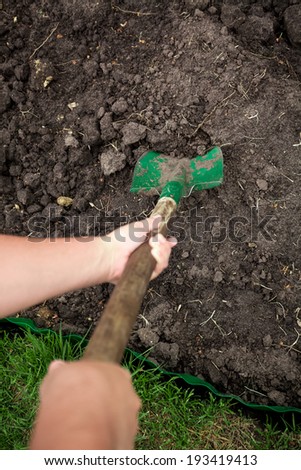 Closeup photo of gardener digging soil with shovel
