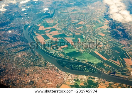 Aerial view from airplane on ground with fields, forest and rivers