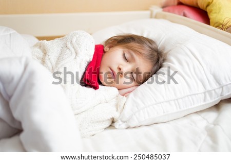Little cute girl with cold sleeping under blanket